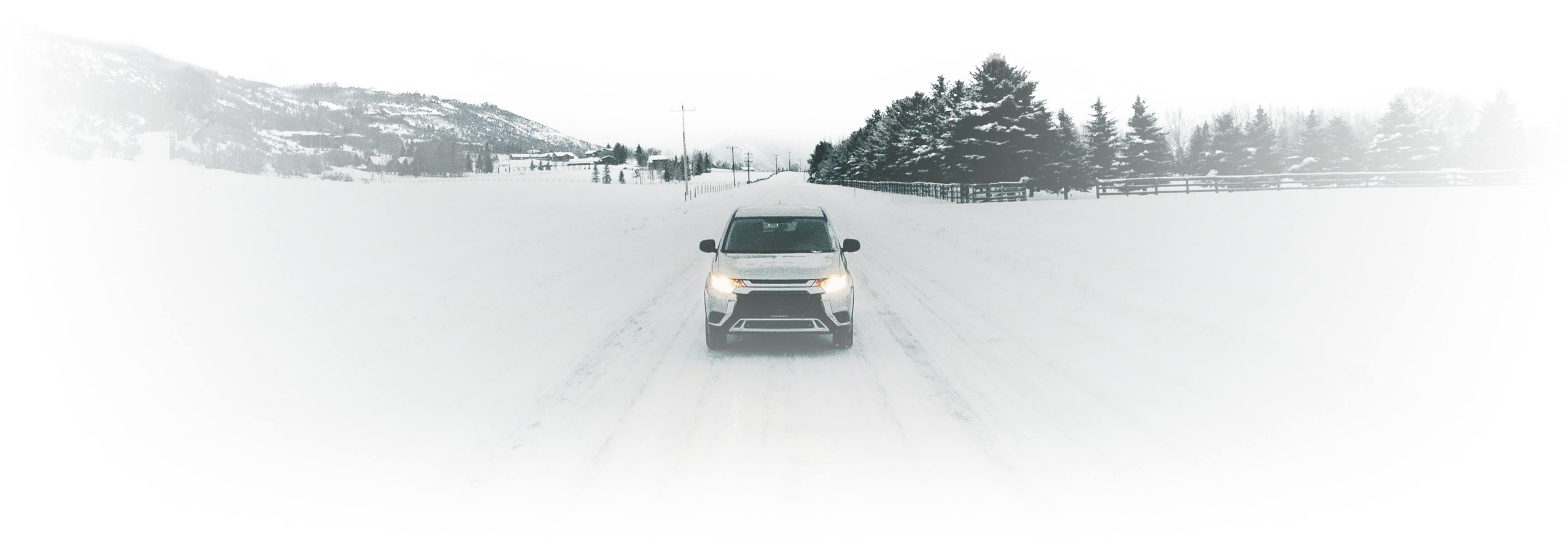 car on a snowy road facing viewer
