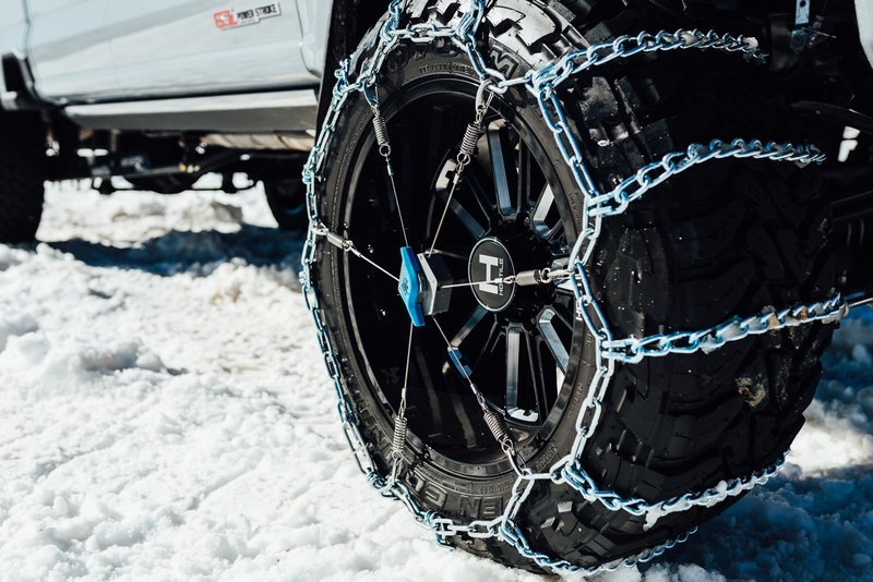 The Kranken snow tire chain tensioner installed on a personal truck